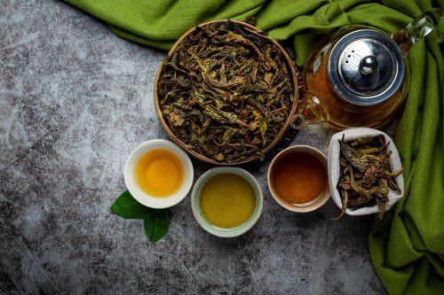 Herbal Tea Retailer display featuring loose-leaf herbal tea, a glass teapot, and cups of freshly brewed tea on a rustic table